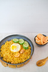 Savory Indonesian Fried Rice Served With A Perfectly Fried Egg, Juicy Shrimp, Fresh Cucumber Slices, And Crackers For A Wholesome Delicious Dish.