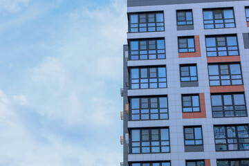 The concept of modern architecture, residential complex, apartment buildings for living. On the right, a close-up of a multi-storey, multi-apartment residential building in gray and white tones with