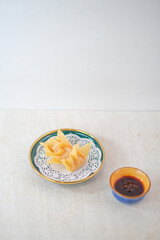Golden Crispy Fried Dumplings Presented On A Stylish Plate Accompanied By A Savory Dipping Sauce For A Perfectly Tasty Snack Experience.