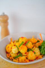 Delicious Crispy Tofu Tossed In Spicy Chili And Salt, Garnished With Fresh Green Scallions And Parsley, Served As A Flavorful Snack In A White Bowl.