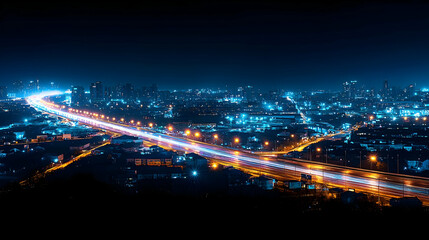 Aerial Cityscape at Night with Illuminated Highway and Blue Sky