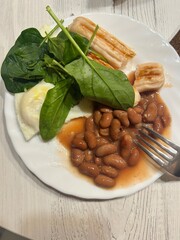 breakfast, scrambled eggs, grilled sausages, spinach and beans in tomato sauce for breakfast
