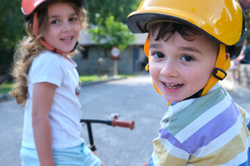 Happy siblings with kick scooters in park