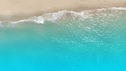 Tropical Beach with the soft wave water of the sea on the sandy beach background as texture with splashes