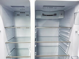 Empty refrigerator with glass shelves in a modern kitchen setting