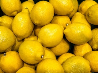Fresh lemons piled together in a vibrant display at a local market