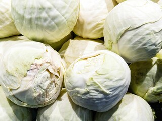 Fresh heads of cabbage stacked in a local market display ready for cooking or crafting dishes