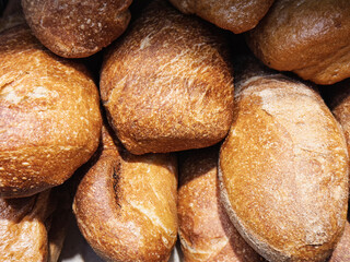 Freshly baked artisanal bread rolls displayed at a bakery in the morning sunlight