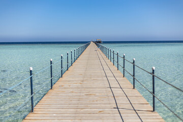 Long wooden pier stretching into the crystal-clear sea of marsa alam, egypt
