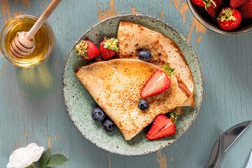 Delicious homemade pancakes with strawberries and blueberries.