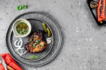 Grilled pork steak on a salad plate. Dark background.