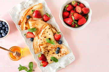 Delicious homemade pancakes with strawberries and blueberries.