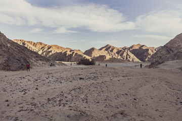 Tourists walking in the egyptian desert of marsa alam at sunset