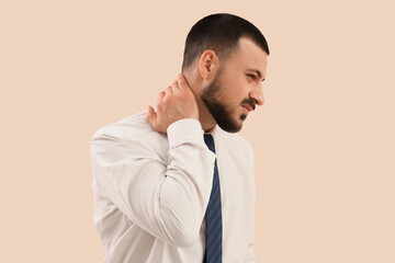 Young businessman suffering from neck pain on light background