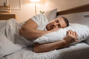 Mature man sleeping in bedroom at night