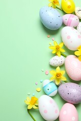 Happy Easter. Colorful eggs and yellow flowers on color background, space for text or advertising
