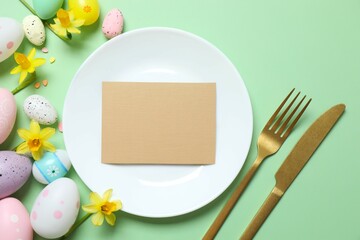 Happy Easter. Top photo with plate, cutlery, eggs, paper card  and flowers on color background with empty space