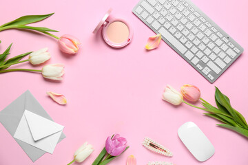 Frame made of beautiful tulip flowers with keyboard, envelopes and facial powder on pink background