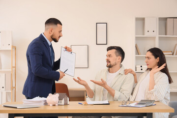 Young couple refusing to sign house rental agreement from real estate agent in office