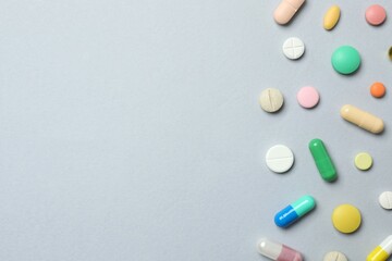 Colorfull pills on gray background, top view