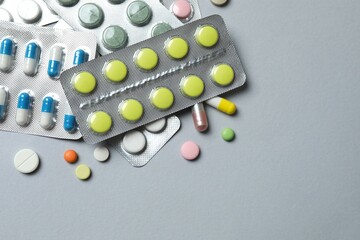 Pills in blister packs on gray background, close up