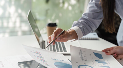 Close-up of professionals discussing financial data and reports in a collaborative office setting.