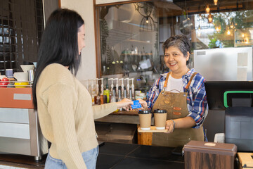 Asian senior people lifestyle small business start-up show credit card cashless payment by customers, elderly pensioner female open cafe coffee shop restaurant, healthy aging woman working as barista