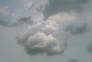 Fluffy Cloud Formation Against Grey Sky With Subtle Sunlight