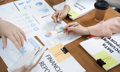 Hands of professionals collaborating on financial reports and data analysis in a modern office...