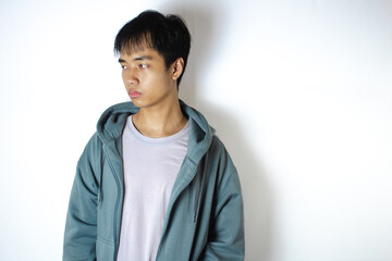 Asian teenager in white t-shirt and blue hoodie, facing right