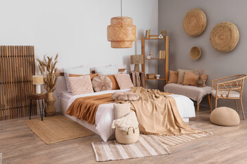 Interior of cozy bedroom with big bed, shelf unit and bench
