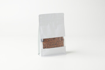 Silver Bag Containing Coffee Beans on a Plain White Background