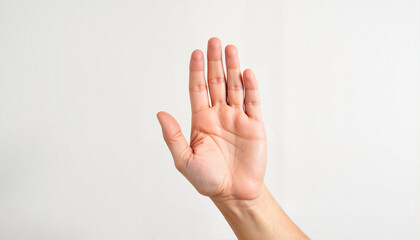 Solitary hand gesturing “stop” against plain wall, clear communication
