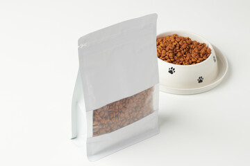Brown Pet Food in a Resealable Bag Next to a Bowl Filled With Kibble