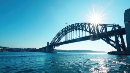Naklejka premium Steel Arch Bridge Silhouette Against a Bright Sun and Serene Water
