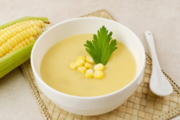 Creamy corn soup in ceramic bowl on the table. Vegetarian food
