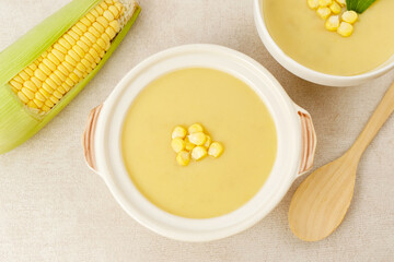Creamy corn soup in ceramic bowl on the table. Vegetarian food
