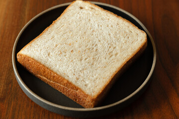 ライ麦と全粒粉を配合した食パンをスライスした断面　木製テーブルの背景