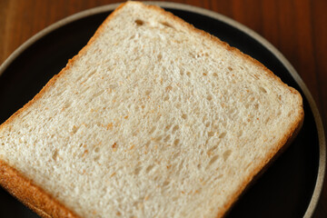 ライ麦と全粒粉を配合した食パンをスライスした断面　木製テーブルの背景