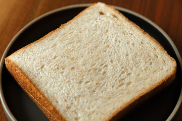 ライ麦と全粒粉を配合した食パンをスライスした断面　木製テーブルの背景