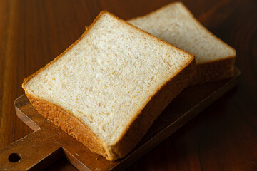 ライ麦と全粒粉を配合した食パンをスライスした断面　木製テーブルの背景