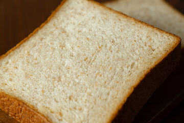 ライ麦と全粒粉を配合した食パンをスライスした断面　木製テーブルの背景
