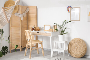 Interior of children's room with table, stool and folding screen