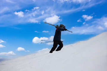 Skier Climbing Snowy Slope on a Clear Day
