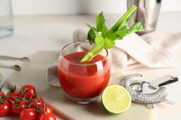 Glass of bloody mary with celery, lime, tomatoes and strainer on light background