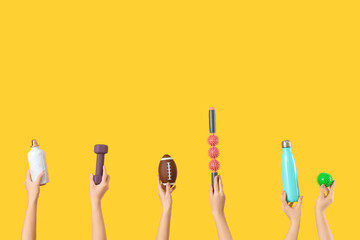 Female hands with sports equipment on yellow background
