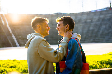 Gay couple sharing intimate moments in urban setting at sunset