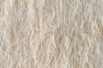 Feathered textured fabric with metallic threads in beige colour, fashion textile close-up