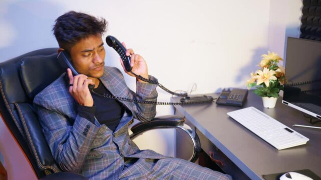 Manager sits in office multitasking duties