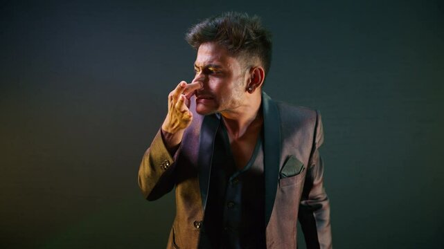 Man stands in formal wear taps nose playfully